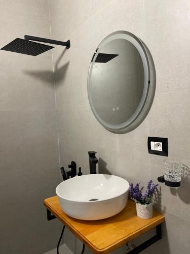 a bathroom with a white sink and a mirror at Shtëpia Me Lule in Përmet