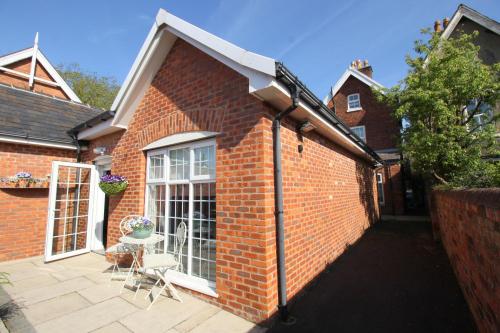 a brick building with a patio with a table and chairs at The Bungalow and Studio Apartments in Lytham St Annes