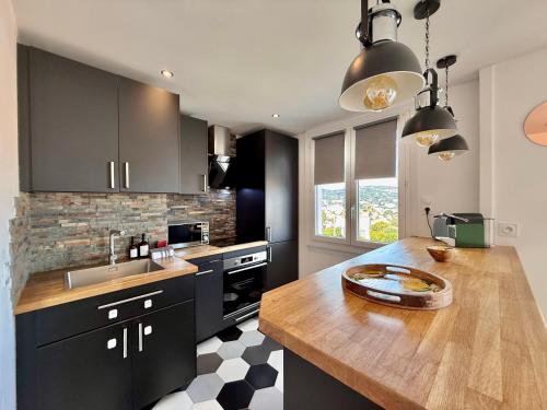 une cuisine avec des armoires noires et un comptoir en bois dans l'établissement T3 Sea view walking distance of Palais, AC , Parking, Terrace, à Cannes
