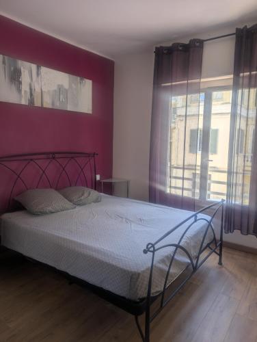 - une chambre dotée d'un lit avec un mur rouge dans l'établissement Appartement Juan les pins, à Antibes