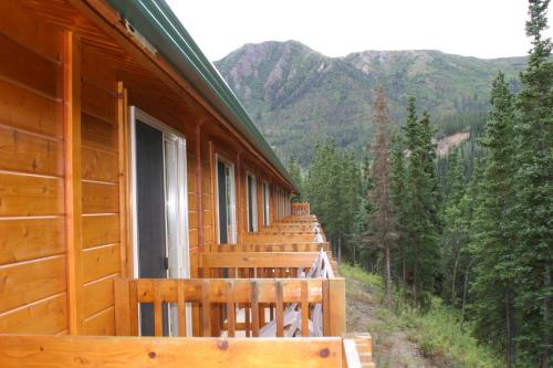 a wooden cabin with a view of a mountain range at Denali Grizzly Bear Resort in McKinley Park