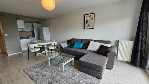 un salon avec un canapé et une table dans l'établissement Francheville - balcon - parking - wifi, à Vannes