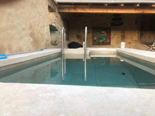 une piscine avec de l'eau bleue dans un immeuble dans l'établissement Maison Principale Poudenas, à Poudenas