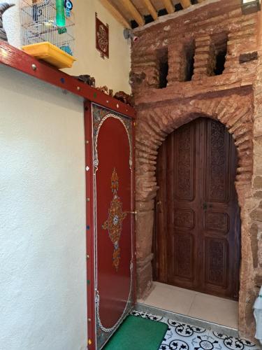 a room with a door in a building with a green floor at Dar Si hmed in Rabat