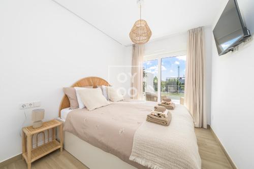 una camera da letto con due letti e una TV di Boho Breeze Penthouse - By Oyoostays a Pilar de la Horadada