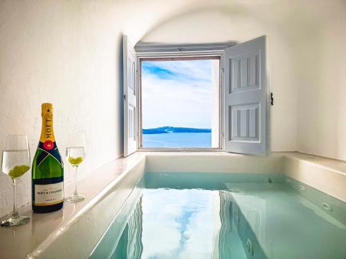 wanna z butelką wina i 2 kieliszkami w obiekcie White Pearl Villas w mieście Oia
