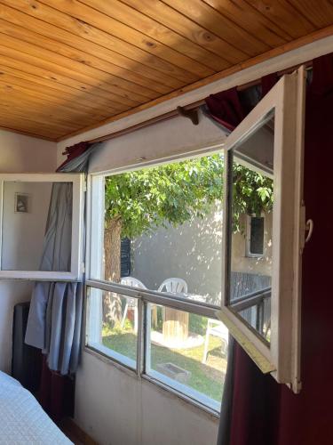 a window in a bedroom with a view of a yard at Apart Los lirios in La Porteña