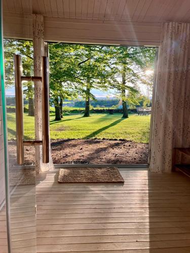 a sliding glass door with a view of a yard at Naturnära Fritidsboende, Tomtebo - YinTorp in Arkelstorp
