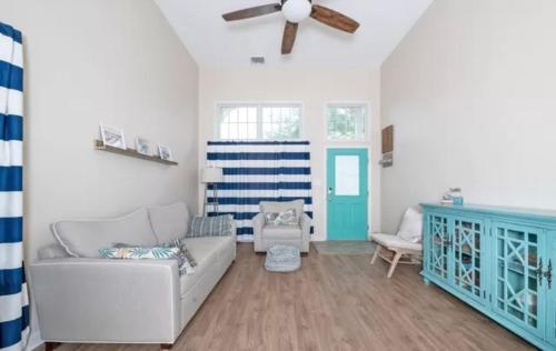 ein Wohnzimmer mit einer Couch und einem Deckenventilator in der Unterkunft Surfside Retreat- Close to Beach & Boardwalk! in Atlantic City