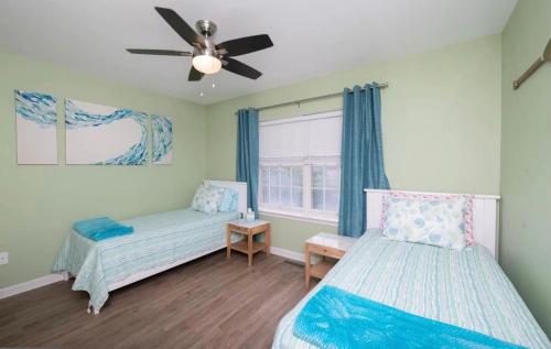 ein Schlafzimmer mit zwei Betten und einem Deckenventilator in der Unterkunft Surfside Retreat- Close to Beach & Boardwalk! in Atlantic City
