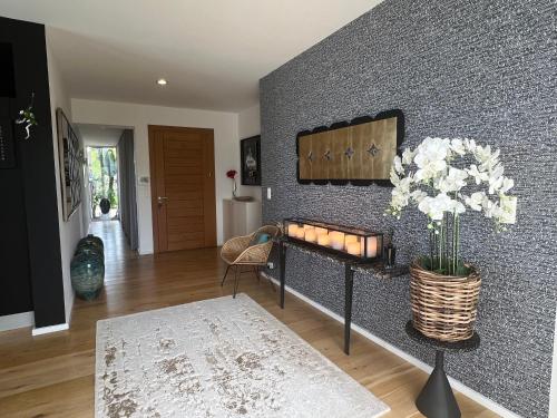 un salon avec un mur avec un vase de fleurs dans l'établissement Giulia, villa exceptionnelle, vue mer et Ajaccio, à Porticcio