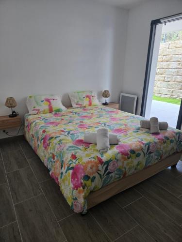 - une chambre avec un grand lit et une couette colorée dans l'établissement Chez Paul et Corinne Appartement Propriano, à Propriano