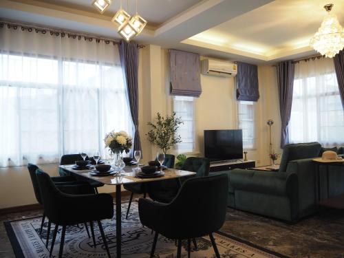 a living room with a table and chairs and a couch at Private 2-storey house in Chiang Mai By The Orchard in Chiang Mai