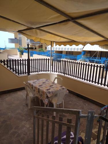 a table and chairs under an umbrella on a patio at Nettuno beachfront house in Nettuno