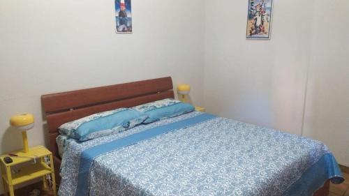 a bedroom with a bed with a blue comforter at Nettuno beachfront house in Nettuno