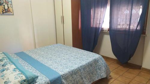 a bedroom with a bed and a window with curtains at Nettuno beachfront house in Nettuno