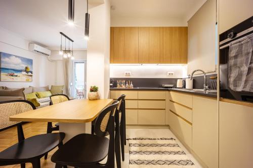 a kitchen and dining room with a wooden table and chairs at Attica Skyline Living! in Athens