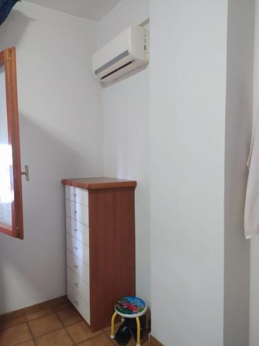 a room with a chest of drawers and a air conditioner at Nettuno beachfront house in Nettuno