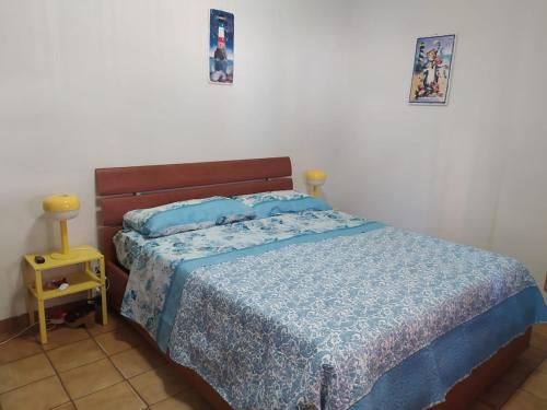 a bedroom with a bed with a blue comforter at Nettuno beachfront house in Nettuno