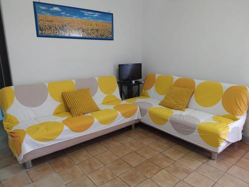 a yellow and white couch in a living room at Nettuno beachfront house in Nettuno