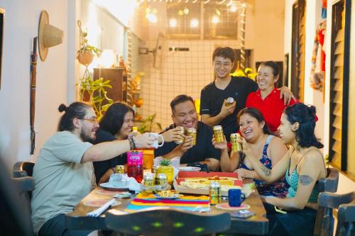 a group of people sitting around a table drinking beer at La Chiva Hostal Armenia in Armenia