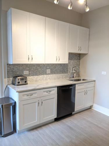 a kitchen with white cabinets and a sink at Spacious Bronzeville Apartment in Chicago