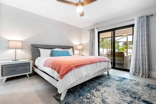 a white bedroom with a bed and a window at 3mins2Beach, Pool, FencedYard, Bikes, Patio, Office in Bonita Springs