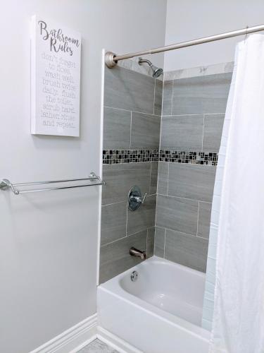 a bathroom with a shower and a tub and a toilet at Spacious Bronzeville Apartment in Chicago