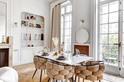 une salle à manger avec une table et des chaises dans l'établissement L'Ecrin Wagram Suite, à Paris