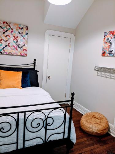 a bedroom with a black bed with an orange pillow at Spacious Bronzeville Apartment in Chicago