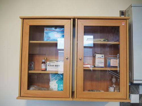 a wooden cabinet with two glass doors at Private 2-storey house in Chiang Mai By The Orchard in Chiang Mai