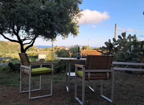 a table with two chairs and a table with wine glasses at Osulai 18 in Santa Maria Navarrese