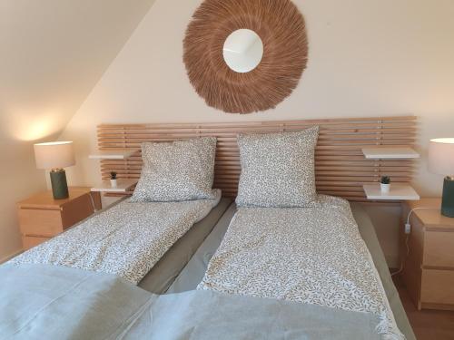 Un dormitorio con dos camas y un espejo en la pared. en Les Tamaris Vue Mer, en Roscoff