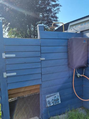 a blue fence with a sink and a chair at Falsterly Glamping in Horbelöv