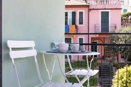 ein Tisch und zwei Stühle auf einem Balkon in der Unterkunft H11 AI CASTELLETTI Mare - Parcheggio in Arma di Taggia