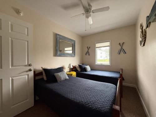 a bedroom with two beds and a ceiling fan at Lake Huron Lodge in Lexington
