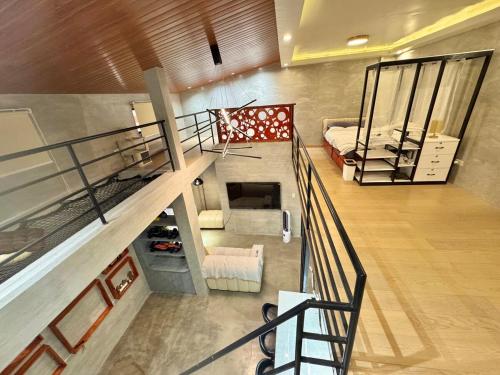 eine Draufsicht auf ein Wohnzimmer mit einer Treppe in der Unterkunft K-Ville - Loft House Near Philippine Arena in Sampong