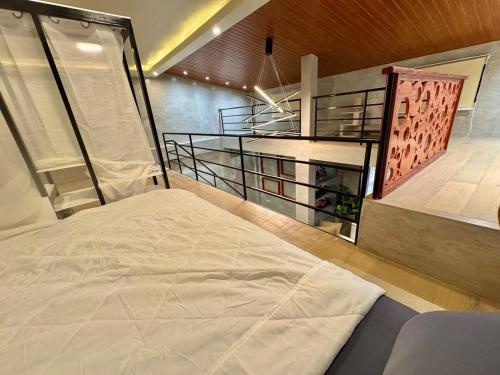 ein Schlafzimmer mit einem großen weißen Bett in einem Zimmer in der Unterkunft K-Ville - Loft House Near Philippine Arena in Sampong