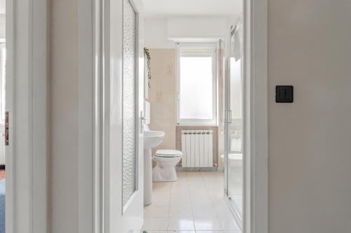 ein weißes Bad mit einem WC und einem Fenster in der Unterkunft H11 AI CASTELLETTI Mare - Parcheggio in Arma di Taggia