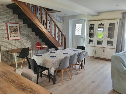 une salle à manger avec une table et des chaises et un escalier dans l'établissement Au cœur du marais, à Nay