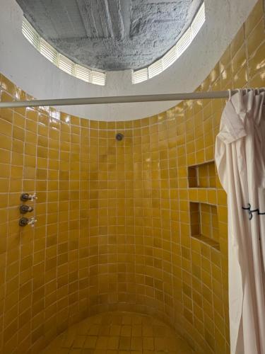 a bathroom with a shower with yellow tiles at Habitación en casa panoramica in Morelia