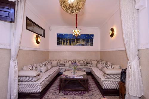 a living room with couches and a chandelier at RIAD KALE POLIS in Marrakech