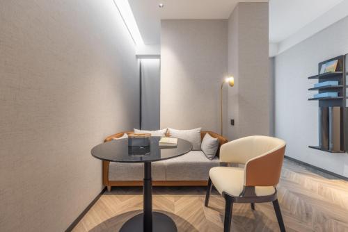 a room with a bed and a table and chairs at Atour S Hotel Shenzhen Luohu Shuibei in Shenzhen