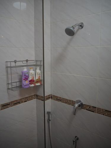 a shower with a glass door in a bathroom at Private 2-storey house in Chiang Mai By The Orchard in Chiang Mai