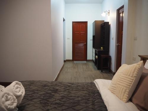a bedroom with a bed and a tv in a room at Private 2-storey house in Chiang Mai By The Orchard in Chiang Mai