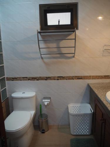 a bathroom with a toilet and a small window at Private 2-storey house in Chiang Mai By The Orchard in Chiang Mai