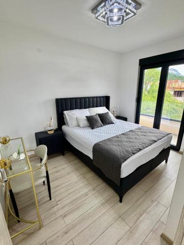 a bedroom with a large bed and a window at S-Penthouse in Herceg-Novi