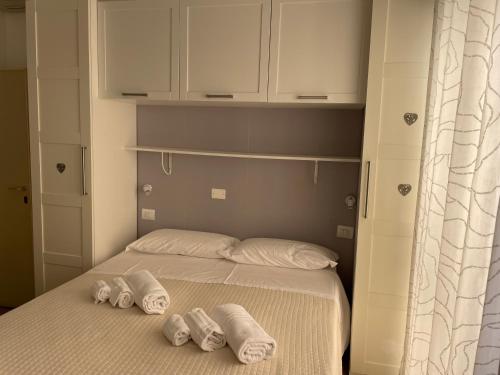 a bedroom with a bed with three towels on it at Hotel Barbiani in Riccione