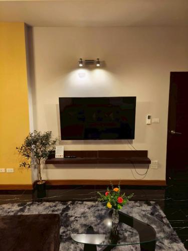 a living room with a large tv on the wall at Private 2-storey house in Chiang Mai By The Orchard in Chiang Mai