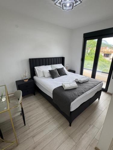 a bedroom with a large bed and a large window at S-Penthouse in Herceg-Novi